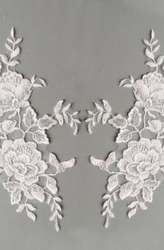 Fehér színű, tüll alapú, dúsan hímzett páros csipke. Szolid, apró átlátszó flitterekkel díszítve